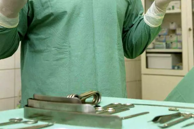 Medicii i-au redat vocea unei femei din Israel. Medic în halat verde, cu mănuși chirurgical, pregătit pentru o operație