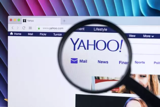 Yahoo! se vinde din nou. Cine ar putea fi cumpărătorul. Lupă deasupra unui logo Yahoo!