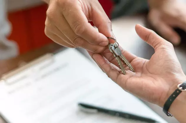 Acte necesare când cumperi un partament în 2020- Mâna unei persoane care oferă chile unui apartament după semnarea actelor