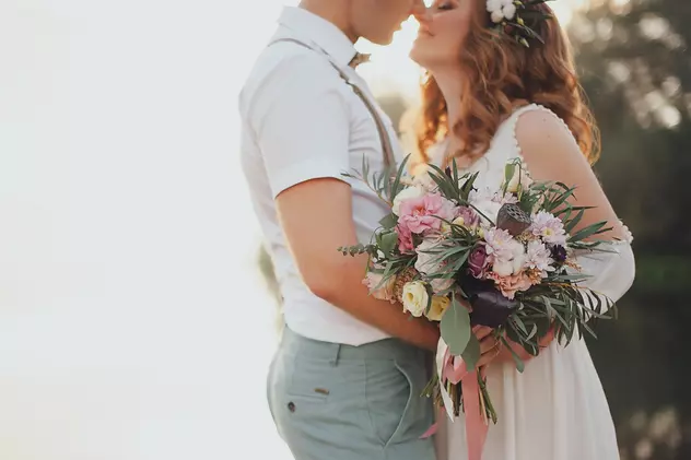Acte necesare căsătorie în 2020- Cuplu - mire și mireasă cu flori în mână