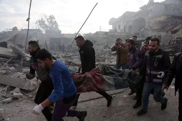 Civili sirieni transportând pe targă o persoană ucisă în război. FOTO: EPA
