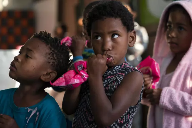 Copii din Africa de Sud, așteptând să primească un pachet de mâncare de la o asociație care se ocupă cu salvarea celor mici de la subnutriție.