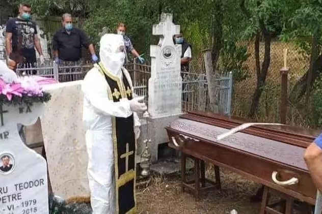 Preot din Olt, în costum de protecție la înmormântarea unei victime COVID-19. ”Mi-am luat măsuri de precauție”