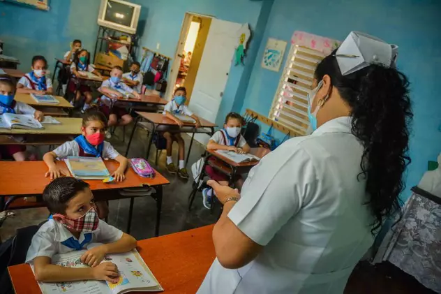 O asistentă le explică elevilor într-o sală de clasă regulile referitoare la respectarea strictă a măsurilor sanitare în instituțiile de învățământ, în Las Tunas, CubaFOTO: EPA-EFE / Yaciel Peña de la Peña EPA-EFE/Yaciel Peña de la Peña
