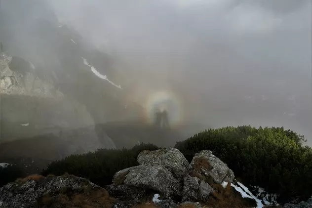 Imagine rară în Munții Bucegi cu umbra unui bărbat proiectată pe un nor și pe ceață, în interiorul unui nimb