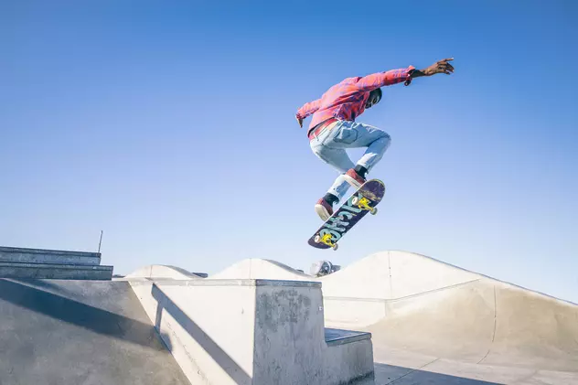 Care sunt cele mai bune skate park-uri din București -un skateboarder face un salt într-un skate park