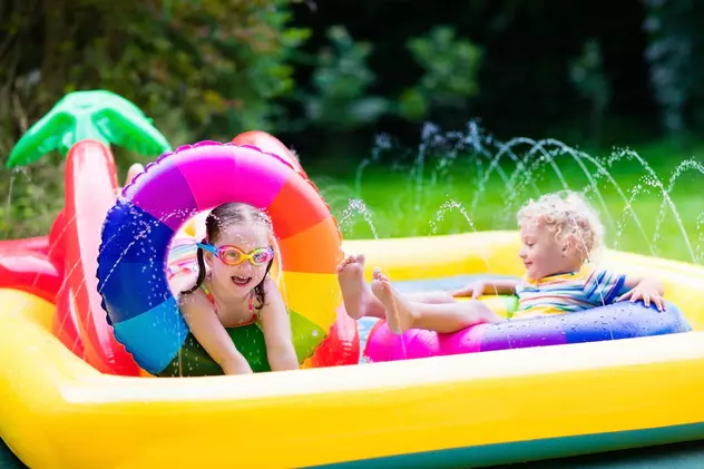 Top 5 piscine gonflabile pentru copii ușor de montat în curte - Doi copii jucându-se într-o piscină gonflabilă