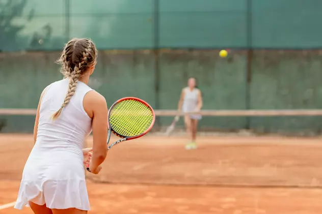 Unde poţi juca tenis de câmp în Bucureşti în 2022 - Imagie cu două fetiţe care joacă tenis pe un teren de zgură.