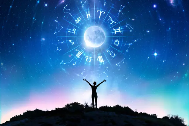 Cele mai norocoase zodii în luna octombrie 2022 - O femeie cu mâinile ridicate în aer, având deasupra ei luna înconjurată de semnele zodiacului