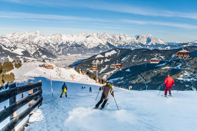 Cum să fii pregătit pentru sezonul de schi - Imagini cu schiori care coboară pe o pârtie din Alpi
