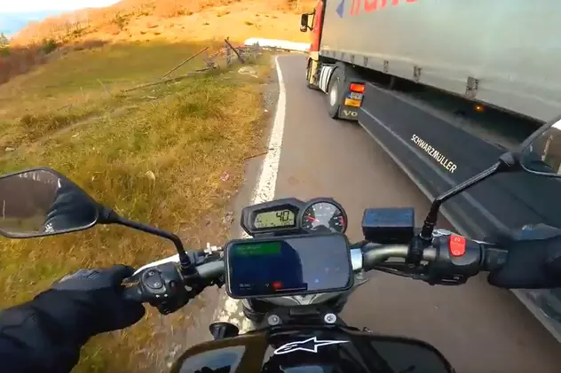 Motociclist aruncat pe câmp de un camionagiu, pe o șosea din România. Amândoi erau peste linia continuă, în curbă | VIDEO