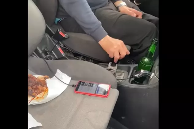 Șofer filmat de o polițistă cu friptura pe bancheta din dreapta și berea lângă schimbător, pe o șosea din Dolj: „Dați muzica mai încet”