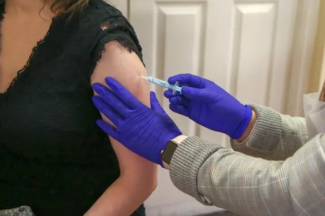 Un asistent medical administrează vaccinul Moderna anti COVID-19 la un centru de vaccinare. Foto: Hepta