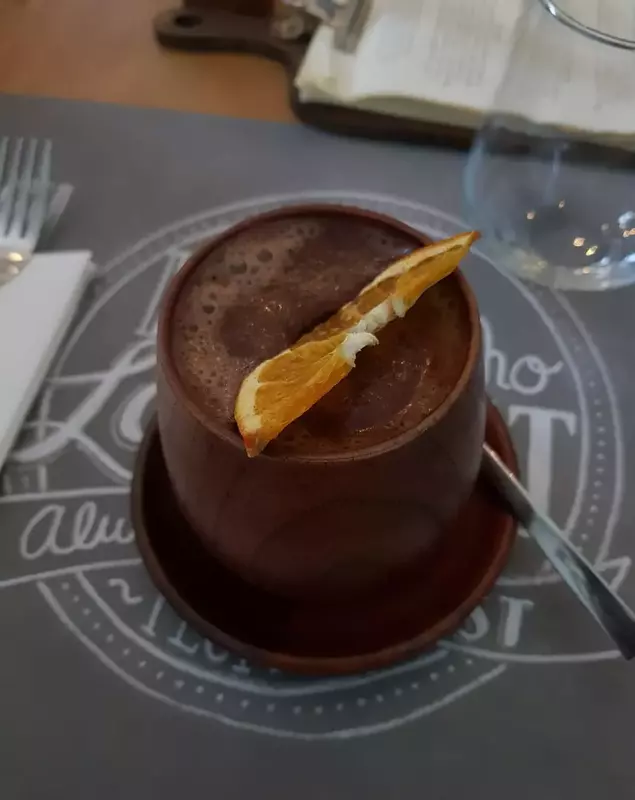 Ciocolată caldă servită cu portocală semideshidratată, în cană din lemn de bambus, care nu transmite căldura