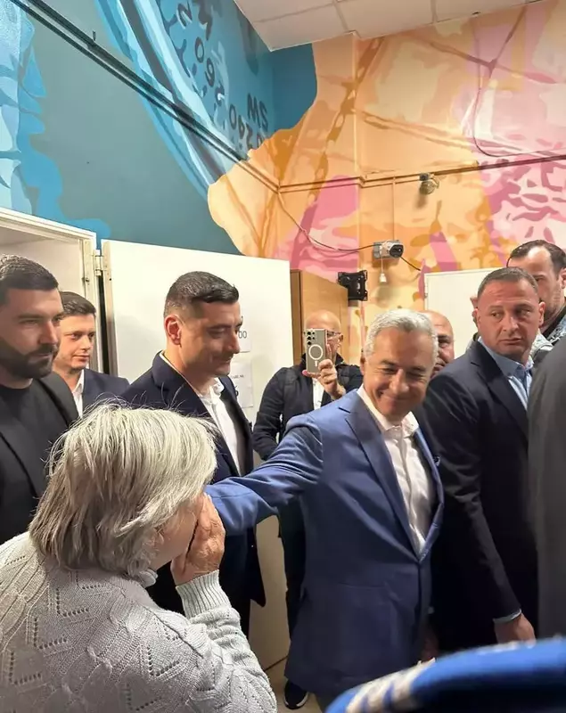 o bătrână îi pupă mâna lui Călin Georgescu