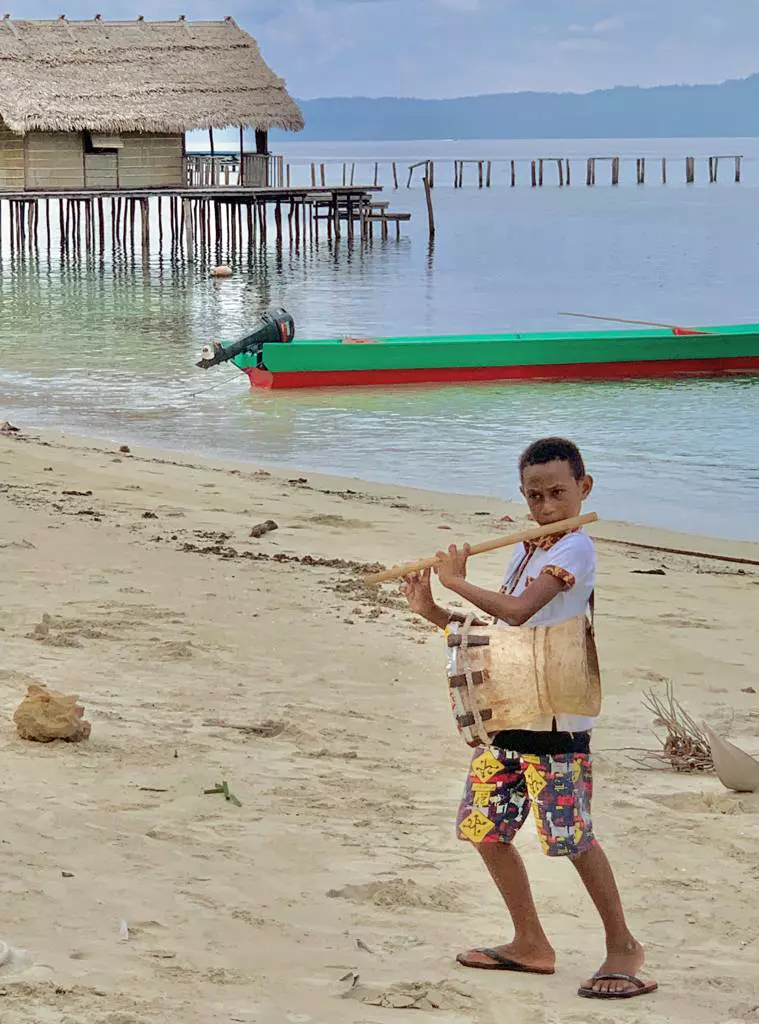 Copil cântând la un instrument tradițional