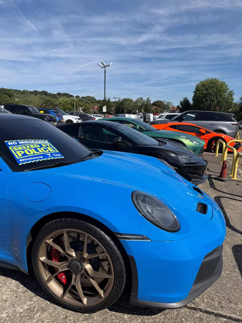 A Porsche, Mclaren and Aston Martin at a police pound after being seized