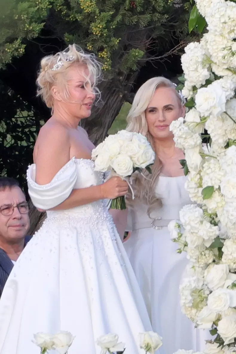 *PREMIUM-EXCLUSIVE* *MUST CALL FOR PRICING * Australian actress Rebel Wilson and her fashion designer fiancée Ramona Agruma look stunning in white wedding dresses as the couple are married in a beautiful ceremony at the Hotel Cala di Volpe in Sardinia