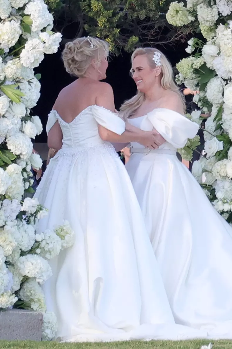 *PREMIUM-EXCLUSIVE* *MUST CALL FOR PRICING * Australian actress Rebel Wilson and her fashion designer fiancée Ramona Agruma look stunning in white wedding dresses as the couple are married in a beautiful ceremony at the Hotel Cala di Volpe in Sardinia