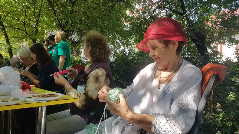 În curtea Casei Memoriale "Tudor Arghezi" are loc o șezătoare a bunicilor care știu să tricoteze. Sunt beneficiare ale Asociației Niciodată Singur