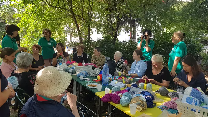 În curtea Casei Memoriale "Tudor Arghezi" are loc o șezătoare a bunicilor care știu să tricoteze. Sunt beneficiare ale Asociației Niciodată Singur