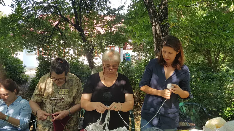 În curtea Casei Memoriale "Tudor Arghezi" are loc o șezătoare a bunicilor care știu să tricoteze. Sunt beneficiare ale Asociației Niciodată Singur