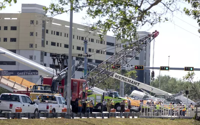 A pedestrian bridge collapses crushing vehicles underneath in Miami o