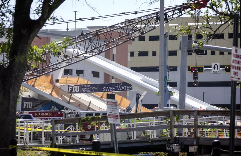 A pedestrian bridge collapses crushing vehicles underneath in Miami o