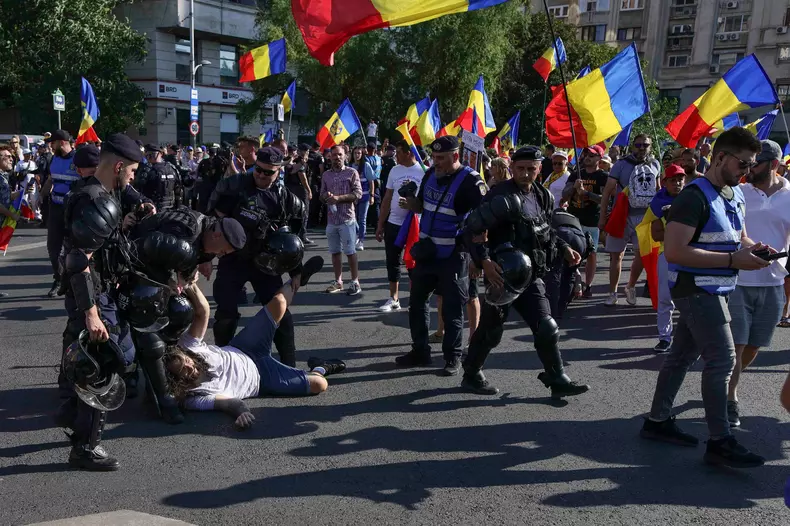 Îmbrânceli între fanii lui Călin Georgescu și jandarmi, la protestul din Piața Victoriei. Foto: Inquam Photos / Octav Ganea