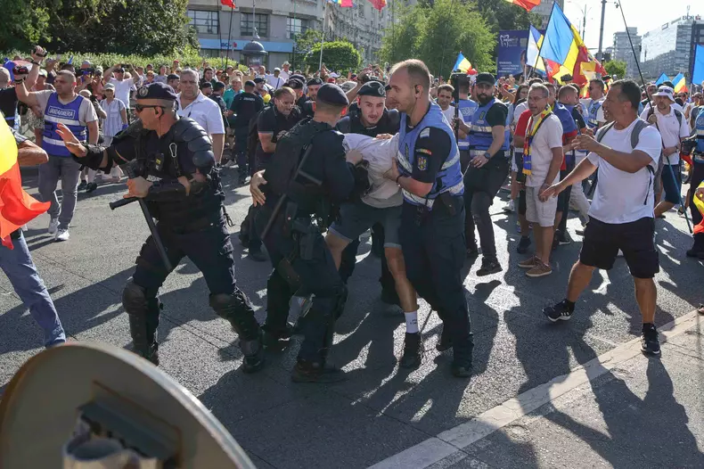Îmbrânceli între fanii lui Călin Georgescu și jandarmi, la protestul din Piața Victoriei. Foto: Inquam Photos / Octav Ganea