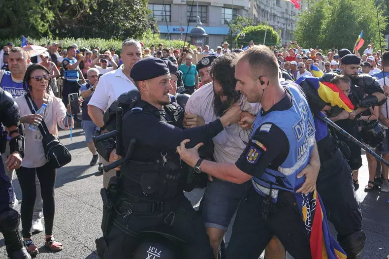 Îmbrânceli între fanii lui Călin Georgescu și jandarmi, la protestul din Piața Victoriei. Foto: Inquam Photos / Octav Ganea