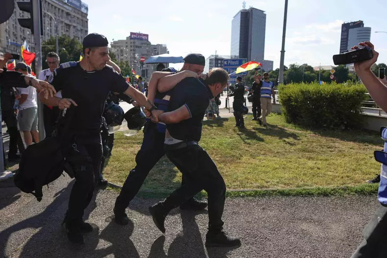 Îmbrânceli între fanii lui Călin Georgescu și jandarmi, la protestul din Piața Victoriei. Foto: Inquam Photos / Octav Ganea