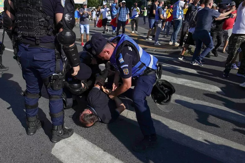 Îmbrânceli între fanii lui Călin Georgescu și jandarmi, la protestul din Piața Victoriei. Foto: Inquam Photos / Octav Ganea