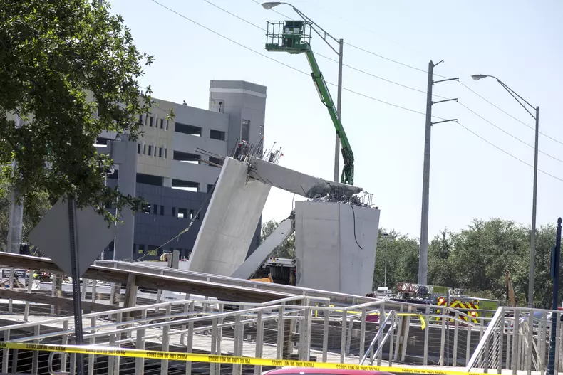 A pedestrian bridge collapses crushing vehicles underneath in Miami o