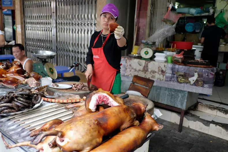 O femeie vinde carne de câine la o tarabă din Hanoi, Vietnam. Autoritațile din Hanoi îndeamnă localnicii să nu mai consume carne de câine. Imaginea orașului de „capitală modernă și civilizată” a fost afectată din pricina comercializării și consumului de carne de câine și pisică, spun autoritățile.