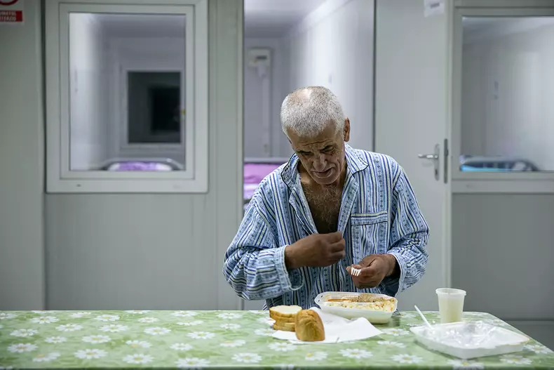 Înainte să servească masă de seară, un bărbat își spune rugăciunea și se închină.