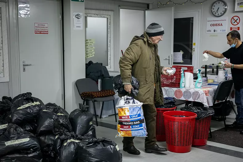 Oamenii care au dormit în adăpost primesc câte un sandviș dimineața înainte de plecare. Unii pleacă când încă este întuneric afară.