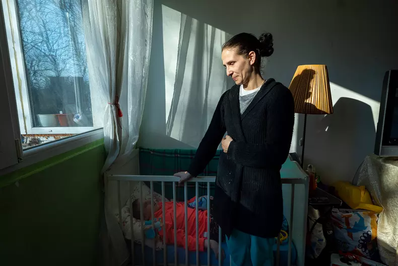 Crina stă lângă pătuțul de bebeluși în care doarme Cristina, fata ei de 16 ani, oarbă, cu retard mintal sever și imobilizată.