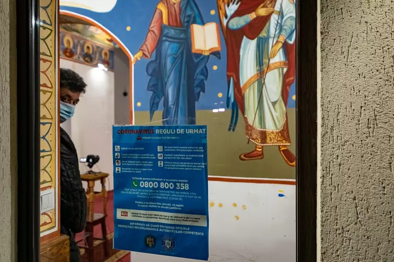 Pe geamul unei biserici din Voluntari este lipit un afiș cu recomandări pentru protecția contra coronavirus. Foto Eli Driu
