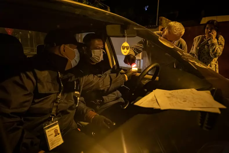 Doi voluntari de deplasează cu mașina pe străzile din orașul Voluntari pentru a da lumină credincioșilor. Foto Eli Driu