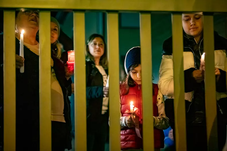 Locuitori din Voluntari au ieșit la poarta casei lor ca să asculte slujba de Înviere de la biserica din apropiere. Foto Eli Driu
