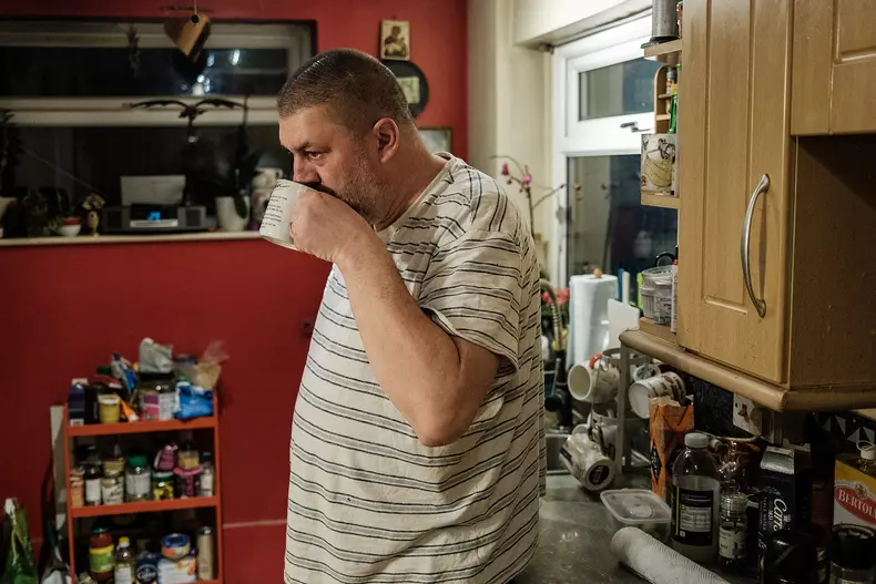 Cătălin își bea cafeaua dimineața în bucătăria familiei din Rugby, UK