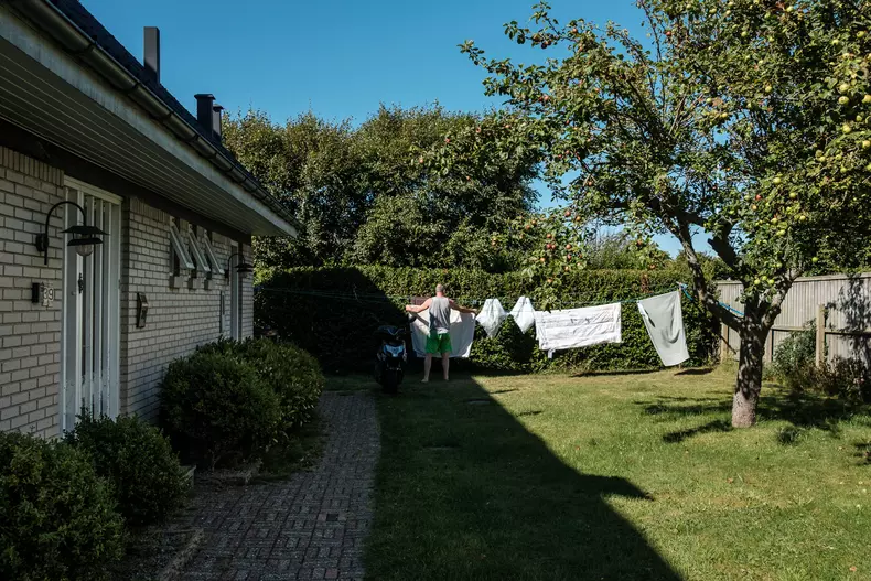 Muncitor român pune hainele la uscat în curtea casei, Skagen, Danemarca