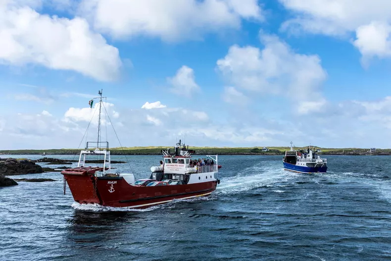 Burtonport, County Donegal, Ireland. 3rd June 2019. One ferry arrives from Arranmore Island passing one departing on a busy Bank Holiday on the north-west coast. The day is windy but reasonably warm 15Celcius. Credit: Richard Wayman/Alamy Live News