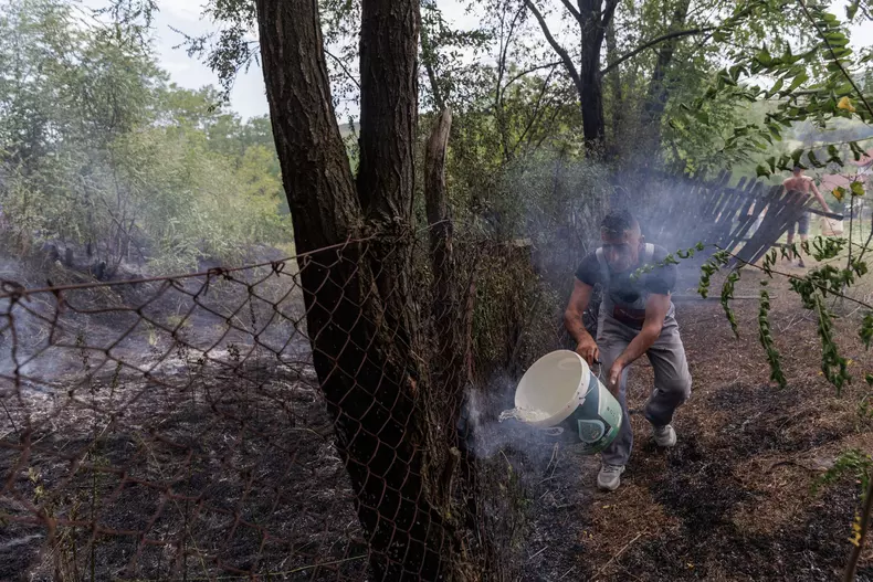 13-un-barbat-toarna-apa-pe-trunchiul-unui-salcam-cuprins-de-foc