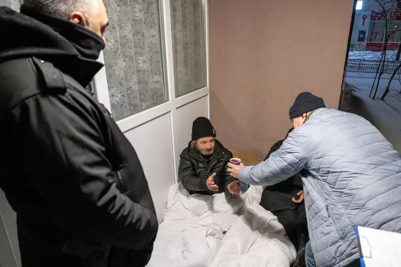 asistentii sociali impart ceai cald persoanelor fara adapost