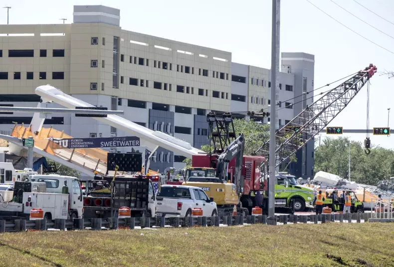A pedestrian bridge collapses crushing vehicles underneath in Miami o