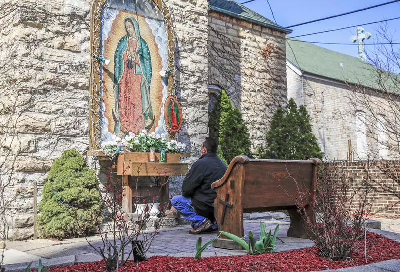 Un bărbat se roagă în fața unui altar al Fecioarei Maria, într-un cartier din Chicago, Illinois. Statele Unite au închis, la fel care și celelalte țări, bisericile