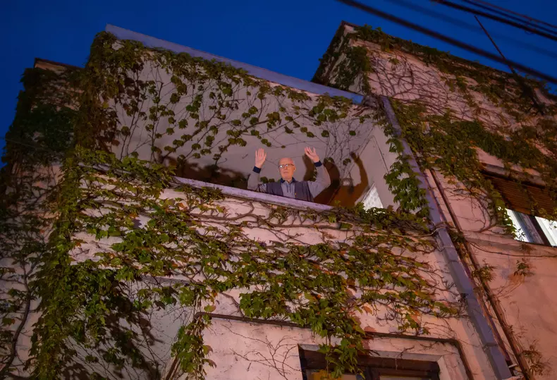 Un bărbat din sectorul 3 îl salută pe preotul Daniel Roșu care a venit sa le aducă Lumina enoriașilor. Foto Vlad Chirea