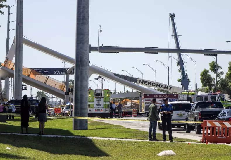 A pedestrian bridge collapses crushing vehicles underneath in Miami o